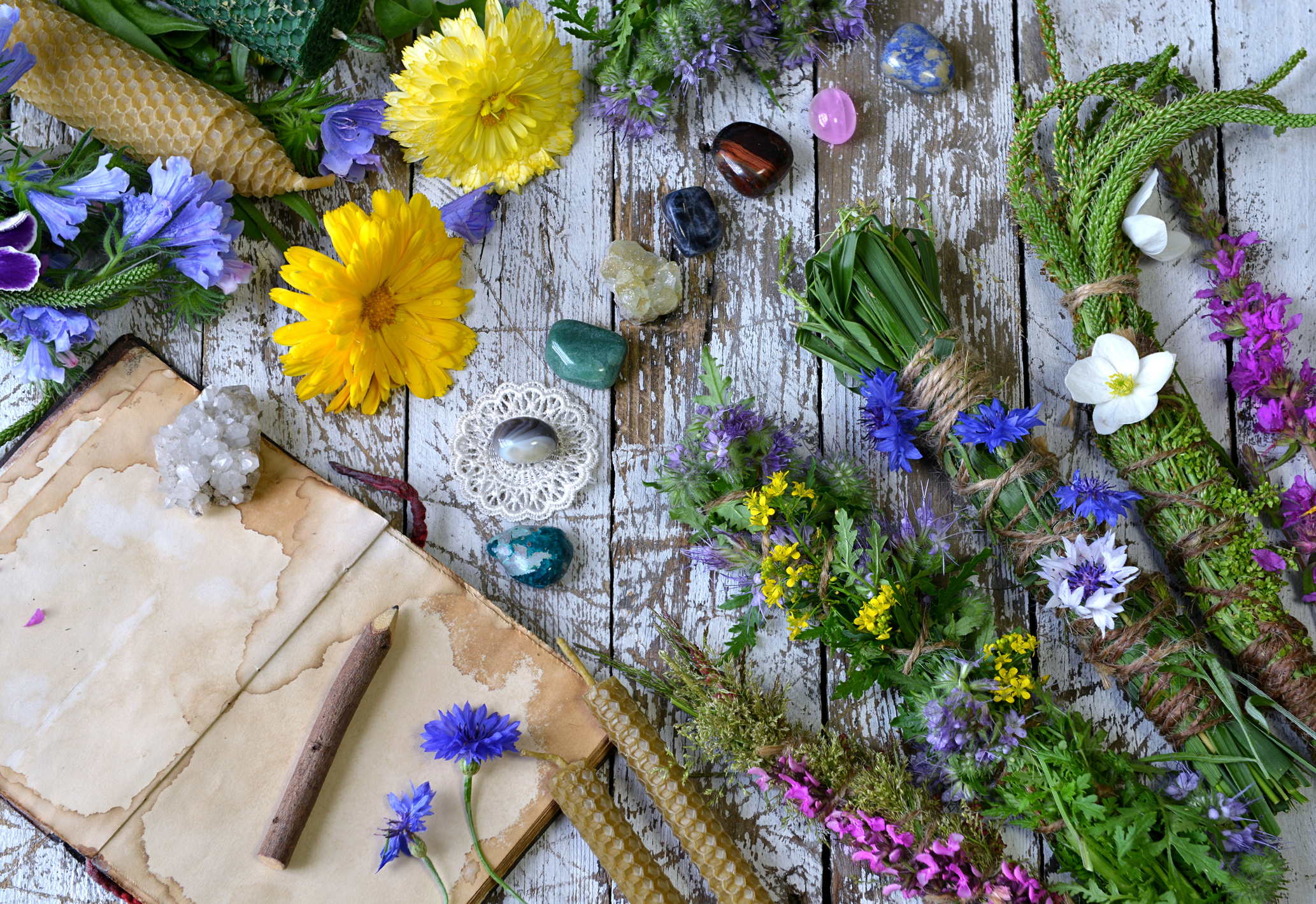 Still life with calendula flowers, herbs, reiki crystals on witch table.